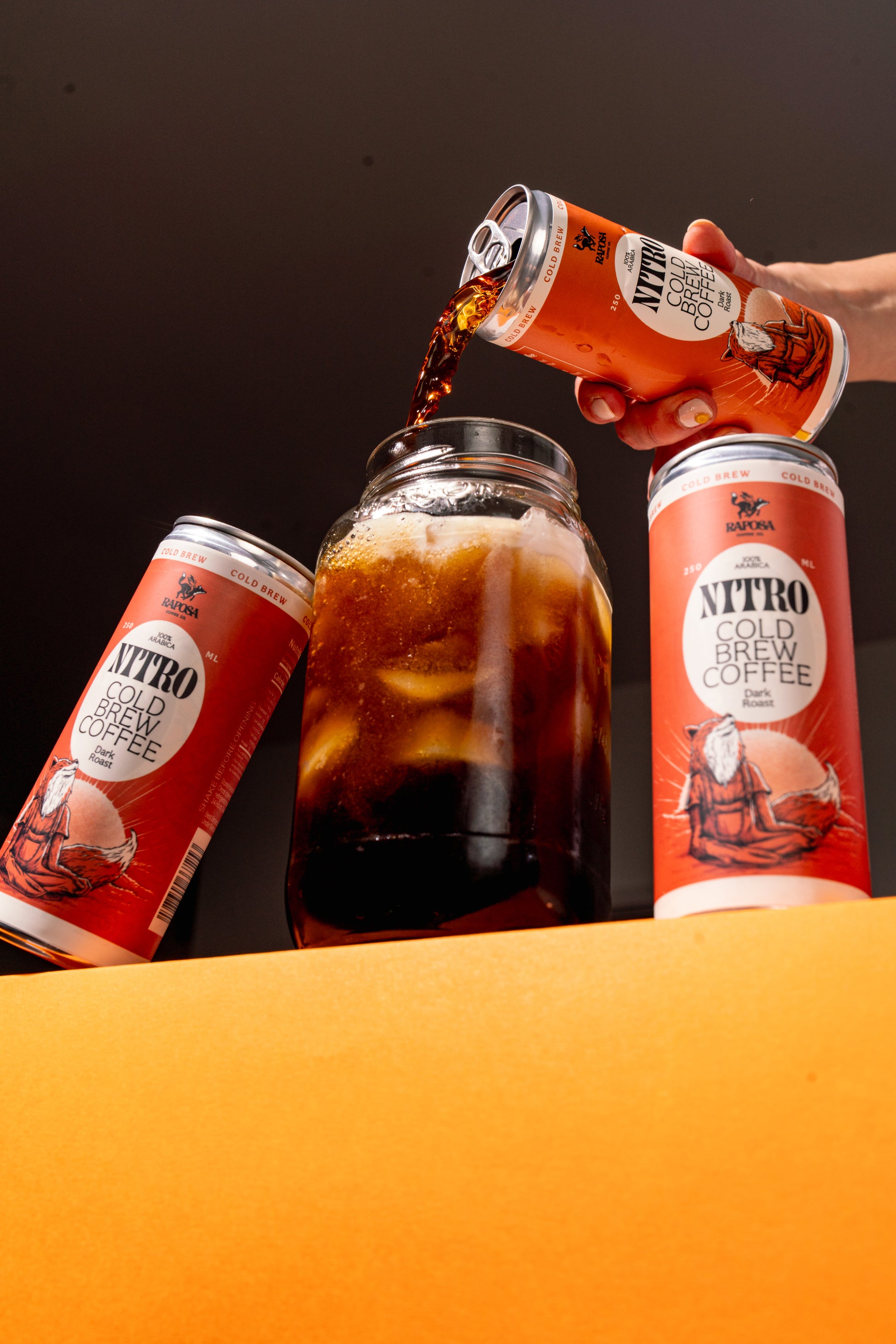 Raposa nitro cold brew coffee pour shot with iced coffee in a glass jar and multiple cans 