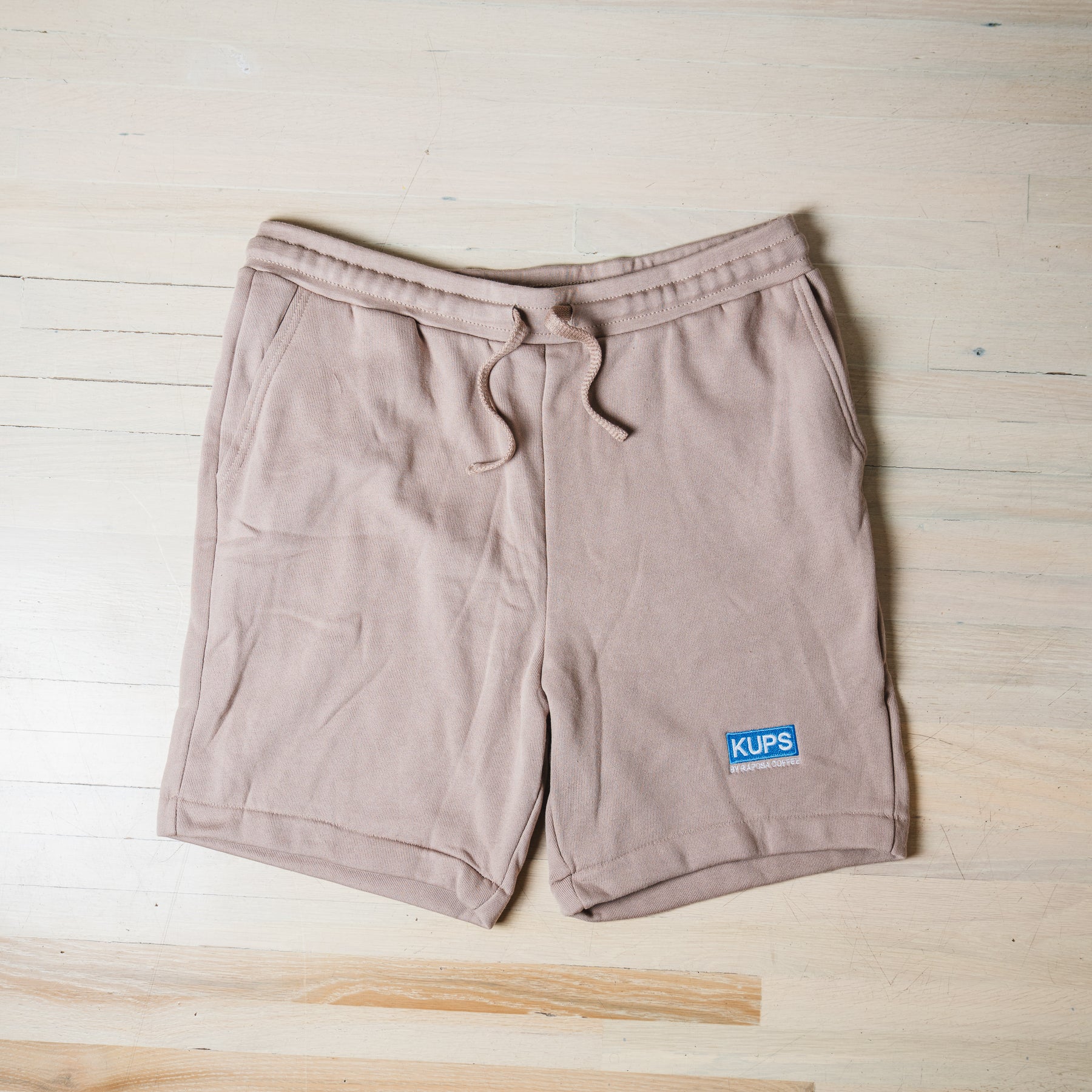 Kups by Raposa Coffee tan fleece shorts flat lay with embroidered logo