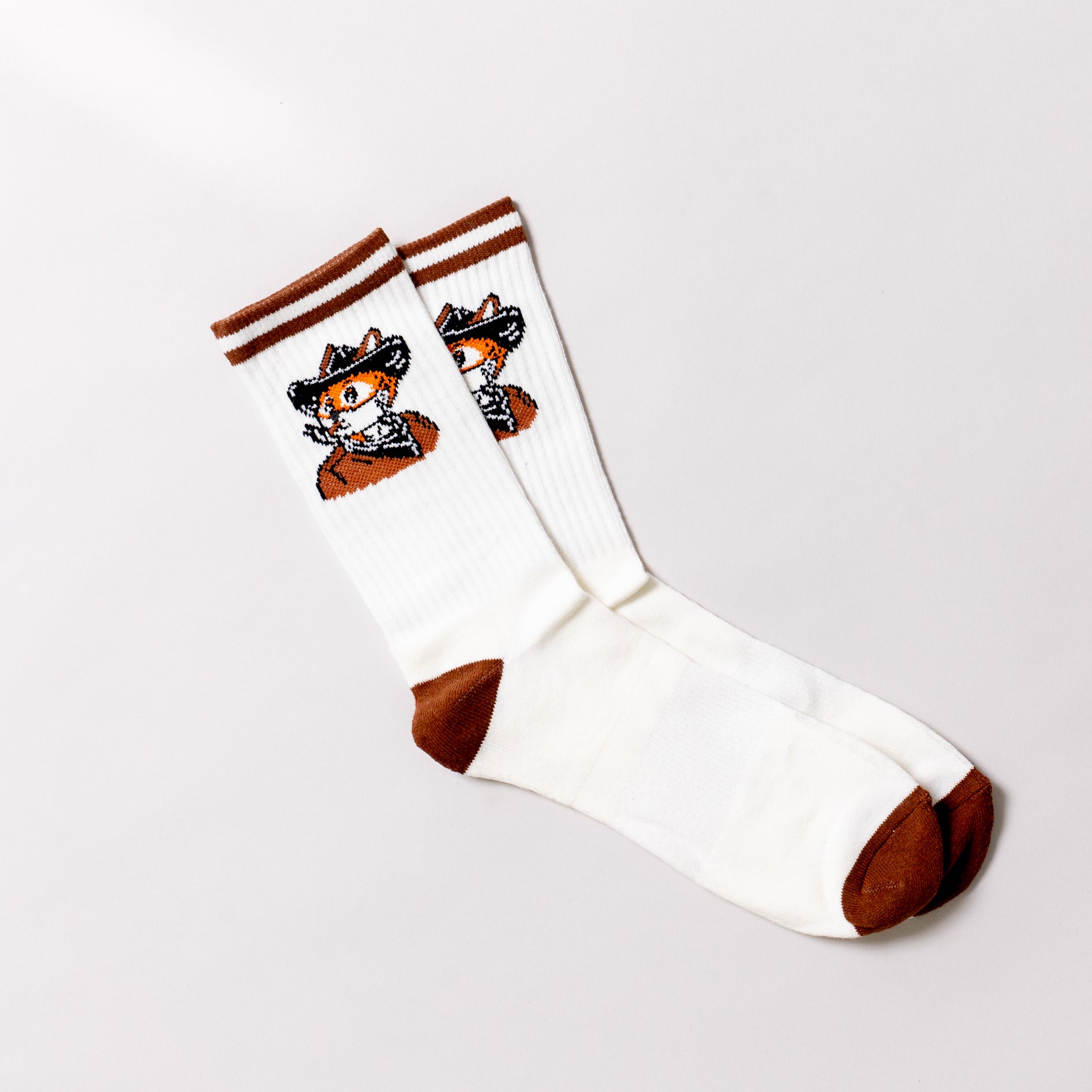 White socks with brown accents and a fox design on a light gray background