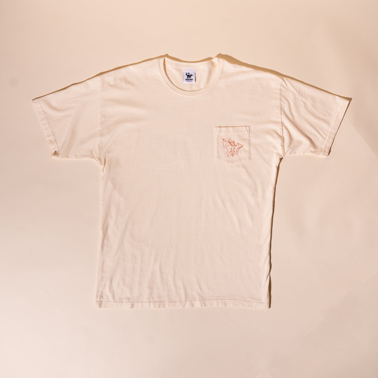 Raposa cream pocket tee flat lay front with pocket logo